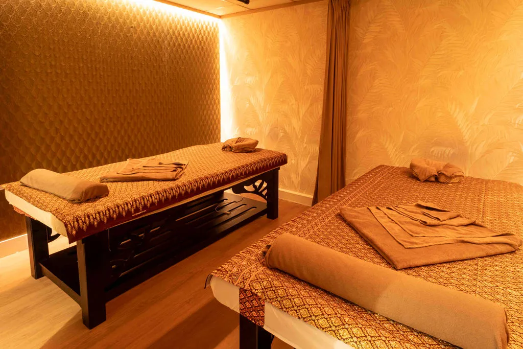 Duokamer met twee massagetafels bedekt met goud-bordeaux Thaise stof